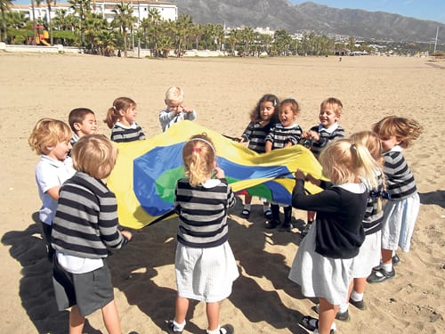 School children playing on beach