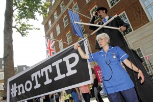12/07/2014 - Protests against the EU-US trade deal (TTIP - Transatlantic Trade and Investment Partnership) outside Europe House, the London Headquarters of the European Commission and the European Parliament, in Smith Square, London. A puppeteer on stilts with a 'puppet' dressed as an NHS nurse to highlight the threat the deal poses to public services like the NHS.