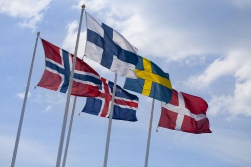 flags of the nordic countries on flag poles against blue sky  afdecbcf