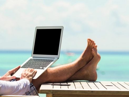 Young Man With Tablet Computer During Tropical Beach Vacation