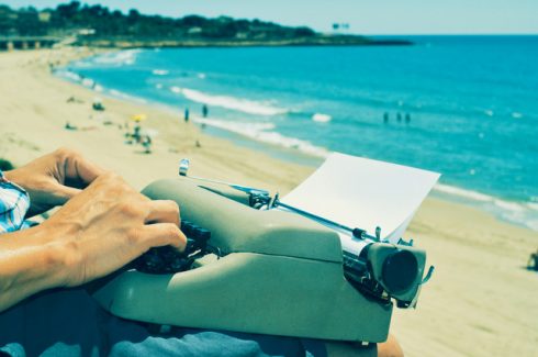 Young Man Typewriting On The Beach
