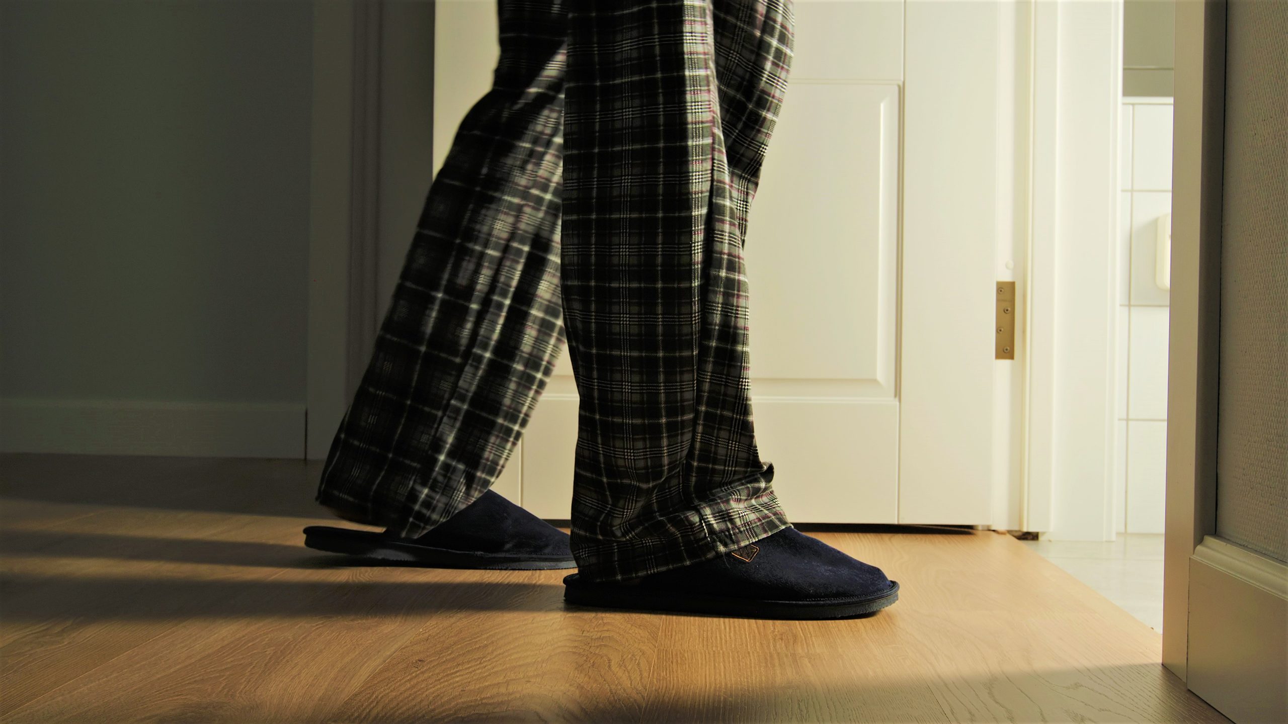 Aged Man In A Pajamas And Slippers Walks To A Toilet At Home In The Night