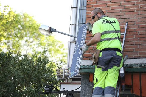 A council worker takes down a street plaque bearing the name of a fascist general