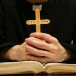 Priest Reading From The Holy Bible  Close Up