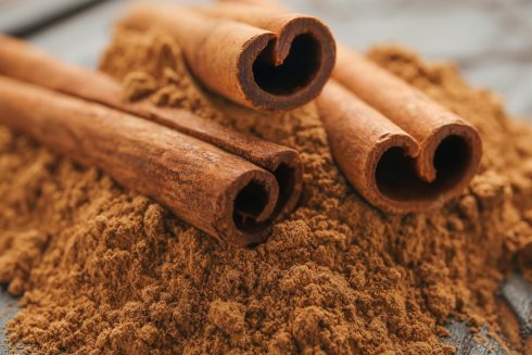 Cinnamon Sticks And Powder On Wooden Background, Closeup