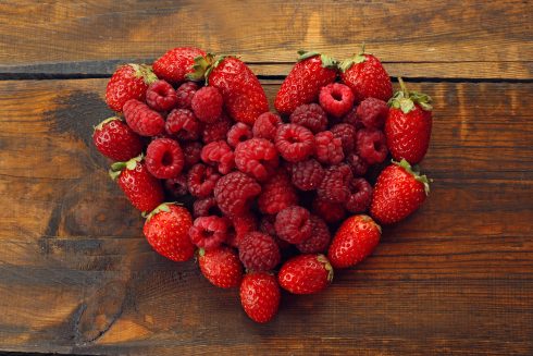 Heart Shaped Strawberries And Raspberries On Wooden Background