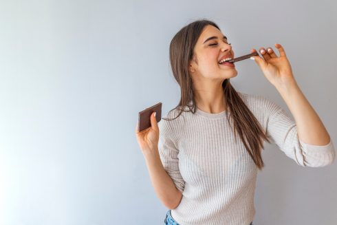 Young Woman With Natural Make Up Having Fun And Eating Chocolat