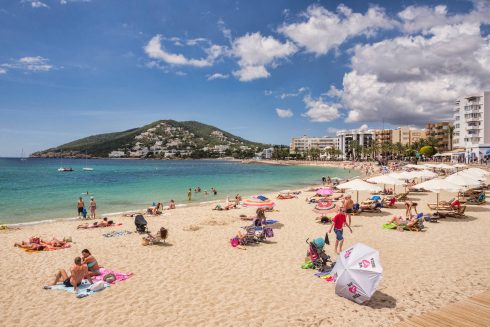 Tourists sun bathing on Ibiza beach