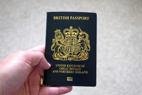 A British passport held in the left hand
