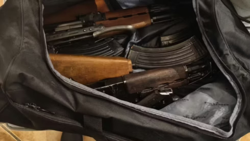 A duffel back filled with AK-47 assault rifles