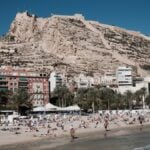 Alicante beach and castle with a mix of foreign and residents on the beach.