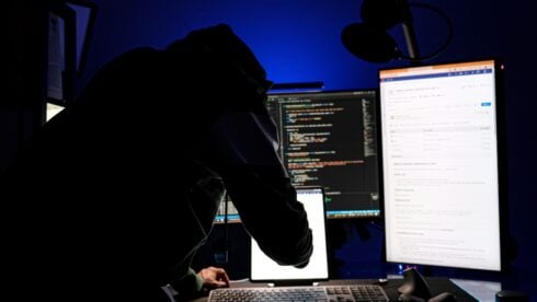 A hacker in front of computer monitors