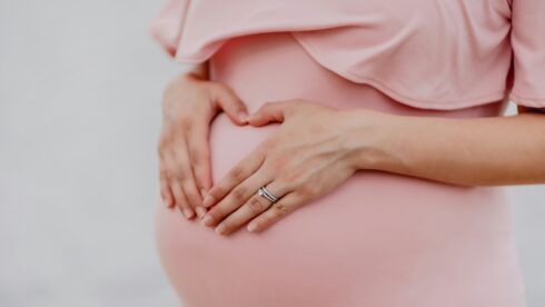A pregnant woman wearing a pink dress